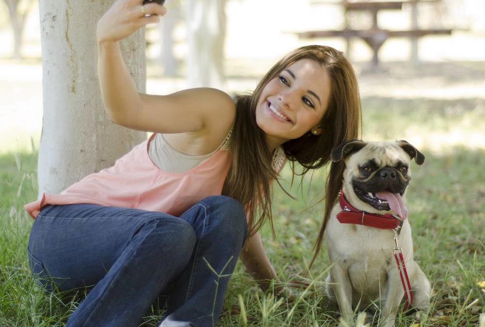 woman taking picture of herself and her dog